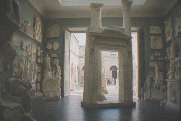 Wax museum gallery interior with velvet ropes, display plinths and warm stage lighting