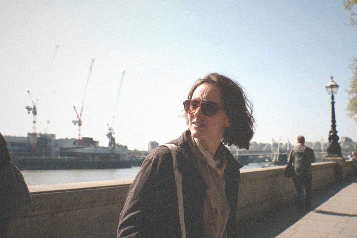 A stone fortress keep with turrets and a grassy moat under a grey sky